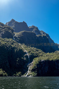 高耸峰林环抱幽深峡湾，飞瀑如练垂挂苍翠山腰