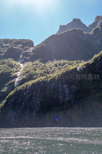 峡湾碧波映衬峻岭飞瀑，蓝帆点缀水面如诗如画