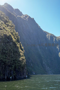 阳光洒落峡湾悬崖，绿植层叠如画屏展开