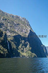 峡湾巨壁巍峨耸立，青翠植被覆盖岩层，瀑布隐现林间