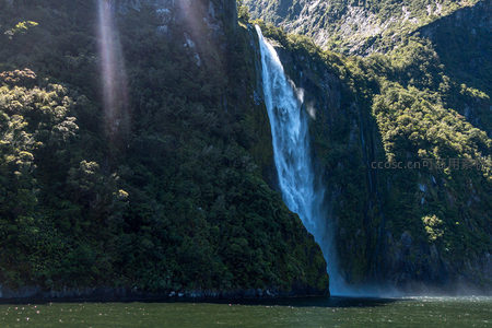 阳光穿林洒向圣灵瀑布，水帘飞溅雾气升腾，绿意盎然