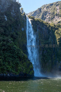 碧水映衬千尺飞瀑，青山环抱中水流如练倾泻入峡湾
