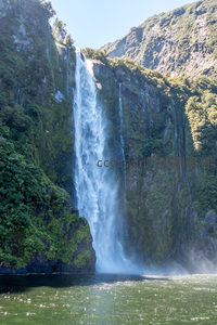 多级瀑布群自悬崖倾泻而下，绿茵覆盖岩壁，水汽氤氲如仙境