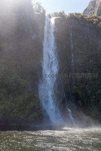 阳光穿透雾气的壮丽瀑布，飞流直下注入碧绿深潭，水花四溅如珠玉散落。