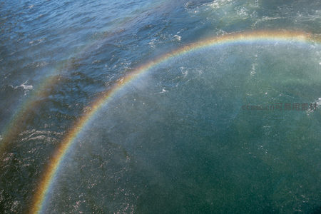 海面双彩虹弧光映照波涛，航拍捕捉水汽折射的自然奇观