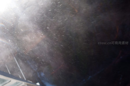 阳光穿透水雾粒子，微距视角捕捉飞溅水珠与光斑交织的动态瞬间