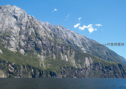 峡湾岩壁巍峨耸立，绿植点缀灰岩绝壁映蓝天