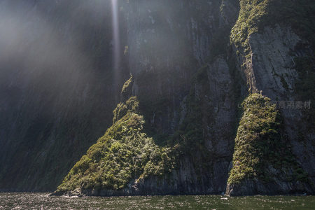 双峰绿岛浮于幽深峡湾，光束如神迹洒落岩壁之间