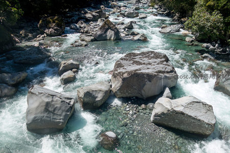 湍急山涧穿石而过，清透碧水激荡巨岩形成白浪花