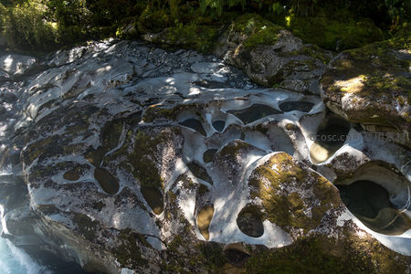河床奇石蚀穴密布，光影交错如天然雕塑群