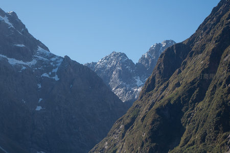 雪峰巍峨映蓝天，峡谷深邃绿意浓