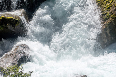 激流飞溅穿岩隙，水花如雪映青苔