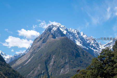 雪峰巍峨耸立蓝天白云下的壮丽山景
