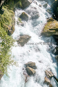 俯拍峡谷急流奔涌，青苔覆岩间水花飞溅，光影交织如诗如画