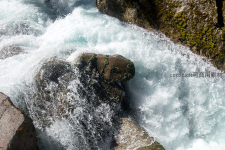 湍急山涧激流冲击青苔覆岩，水花飞溅如雪