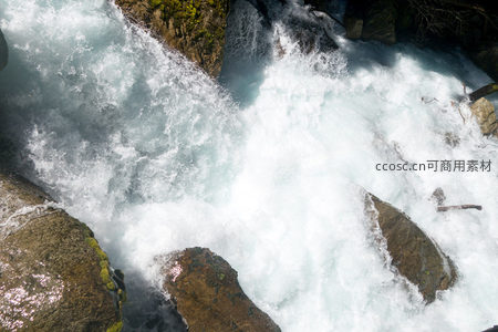 俯视视角下激流撞岩爆裂，水雾弥漫如烟似雪