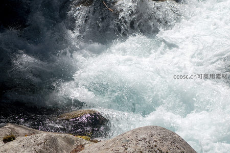 峡谷激流翻腾白浪，光影交错映照嶙峋石岸