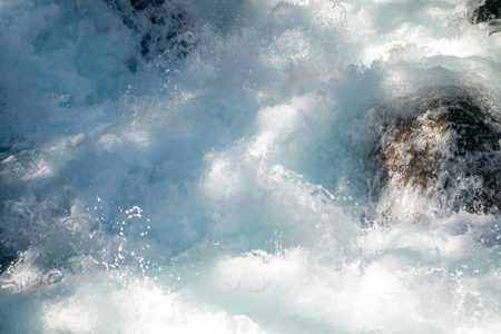 浪花炸裂瞬间定格，水珠悬浮如星尘，岩石隐现于混沌白幕中