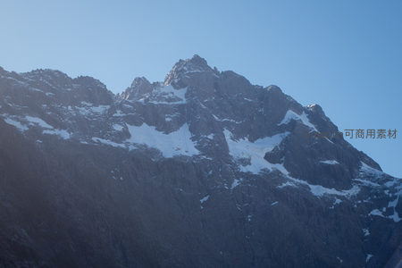 巍峨雪峰刺破澄蓝天幕，岩脊嶙峋积雪斑驳，尽显高山雄浑气魄