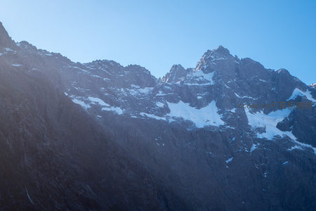 峻岭积雪斑驳，岩壁嶙峋在晴空下显巍峨气势