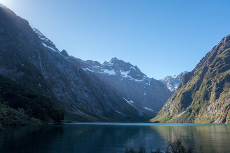 阳光斜照山谷，冰川融水汇入湖面，山色层次分明如画卷展开