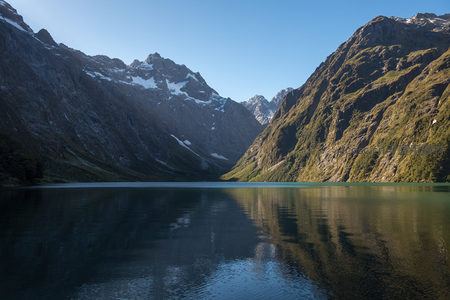双峰夹峙湖心，倒影对称如工笔画，清透湖水映出山体肌理细节