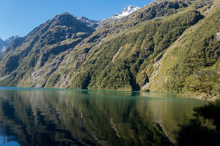 湖光山色交相辉映，陡峭山崖覆满青翠林木