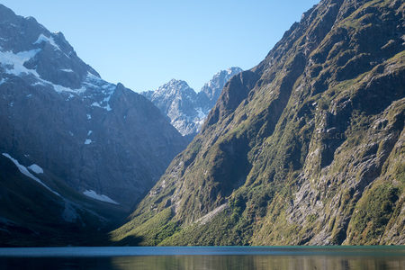 U型冰川谷地中的翡翠湖泊，两侧峭壁耸立入云