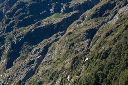 航拍陡峭山崖植被覆盖细节，光影交错展现地质纹理与生态层次