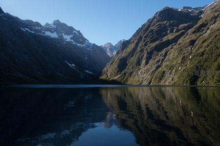 深蓝湖面映雪山，峡谷幽深绿意浓，天地一色静无声
