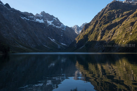 湖光山色交相辉映，雪峰倒影随波微漾，山谷光影交错展现自然和谐