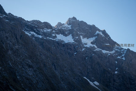 锯齿状雪峰刺破晴空，岩脊嶙峋积雪点缀其间