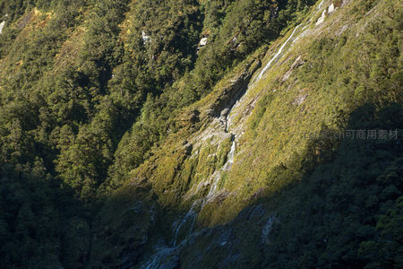 阳光穿透林隙洒落山涧，多级细瀑串连绿谷