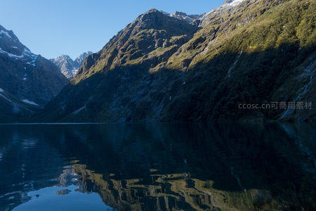 高山湖泊静谧倒影，雪峰与翠岭映照水面如镜