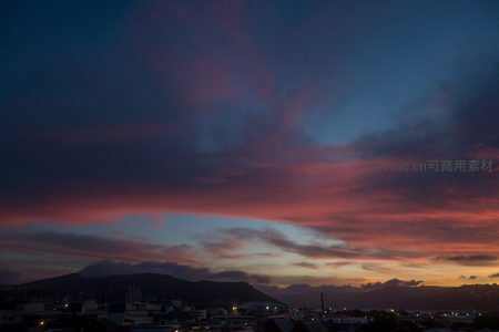 暮色中的城市轮廓，粉紫云霞低垂如焰