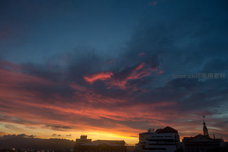 霞光穿云洒向城郭，现代楼宇与古典塔楼共映