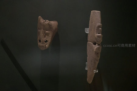 玛雅风格陶塑面具与人形立像并置陈列，深色背景凸显古文明神秘气质