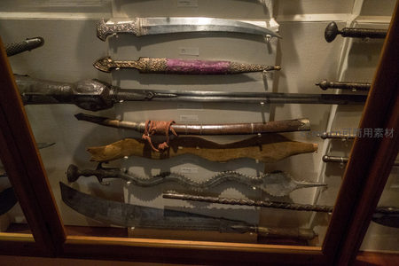 木质展柜内多层陈列的异形刀剑与特色刀鞘组合