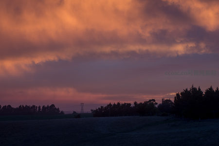 紫霞漫卷天幕，林线隐现于渐暗大地之上