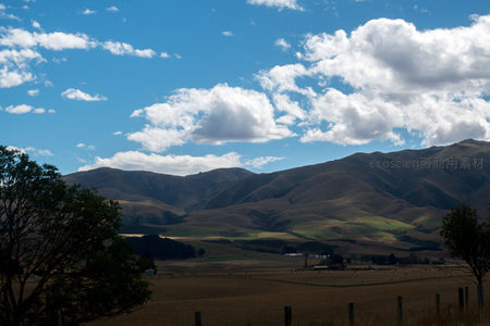 山峦起伏间云影流动，农舍隐现谷地的壮丽乡野全景