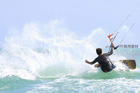 风筝冲浪者腾空溅起巨浪，碧海蓝天间尽显动感活力