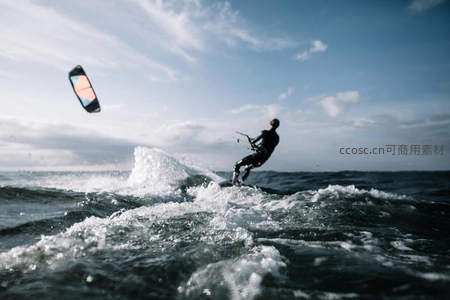 风筝冲浪者在碧海浪尖腾空跃起，彩色风筝划破蓝天