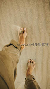 赤足踏沙，细沙从脚趾间滑落的瞬间特写