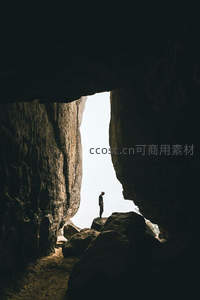 洞穴之门：剪影旅人伫立岩隙间眺望光明天地
