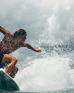 冲浪者在巨浪中疾驰腾跃，水花飞溅间展现力量与速度的动感瞬间