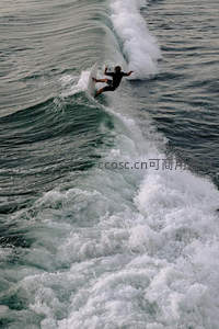 冲浪者乘浪腾空，在碧绿海浪中展现动感瞬间