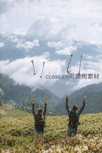 徒步情侣在高山草甸抛掷登山杖，云海翻腾映衬欢愉瞬间