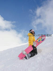 雪坡上女孩怀抱粉色彩绘单板，笑容灿烂迎向蓝天白云