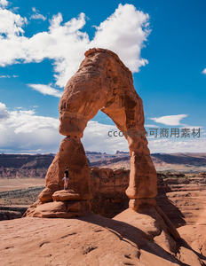 拱门国家公园 Delicate Arch 下游客驻足，红岩巨构与蓝天白云共舞