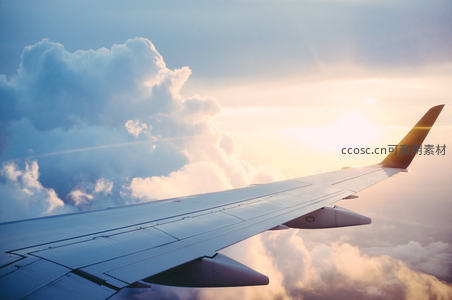 飞机翼尖掠过云海，夕阳余晖洒满天际的壮丽航拍瞬间